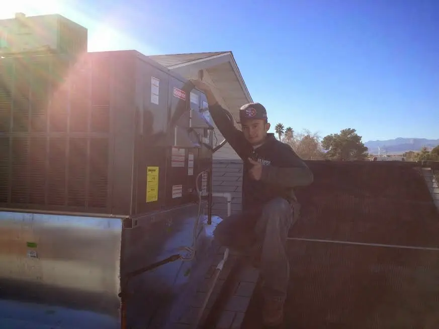 HVAC technician performing AC Tune-Up on a rooftop unit in West Falls Church